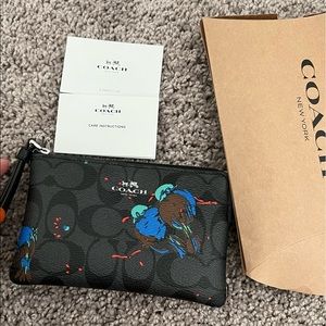 BRAND NEW: Black-grey Coach Wristlet w/ bird print. never worn. Still in box.